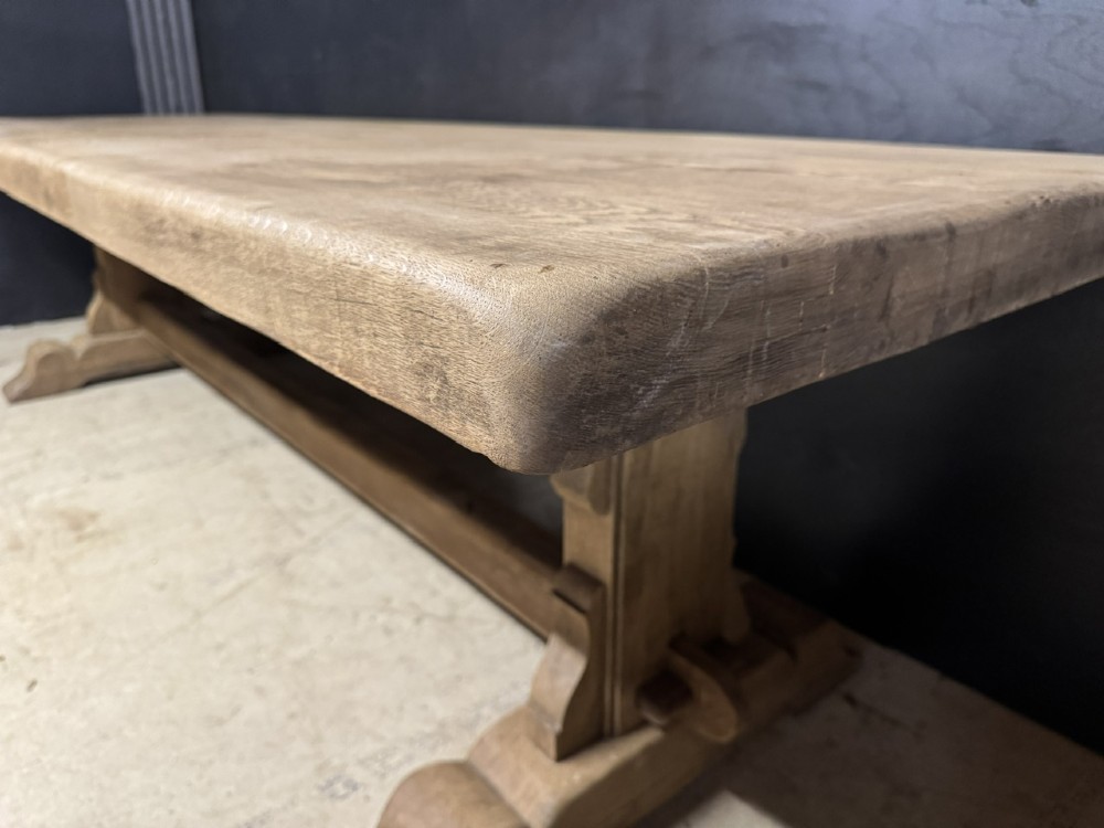 A long French oak trestle dining table featuring a thick wooden top, robust pedestal supports, and a central stretcher with pegged joints. View XI