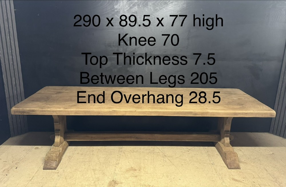 A long French oak trestle dining table featuring a thick wooden top, robust pedestal supports, and a central stretcher with pegged joints. View XIII