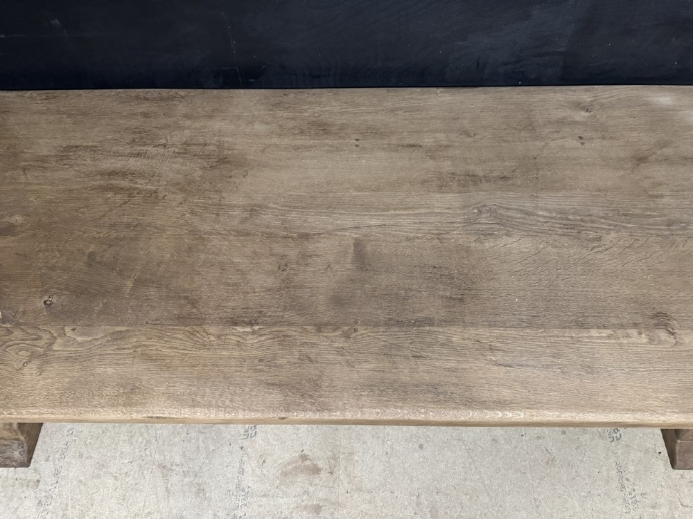 A long French oak trestle dining table featuring a thick wooden top, robust pedestal supports, and a central stretcher with pegged joints. View XIV