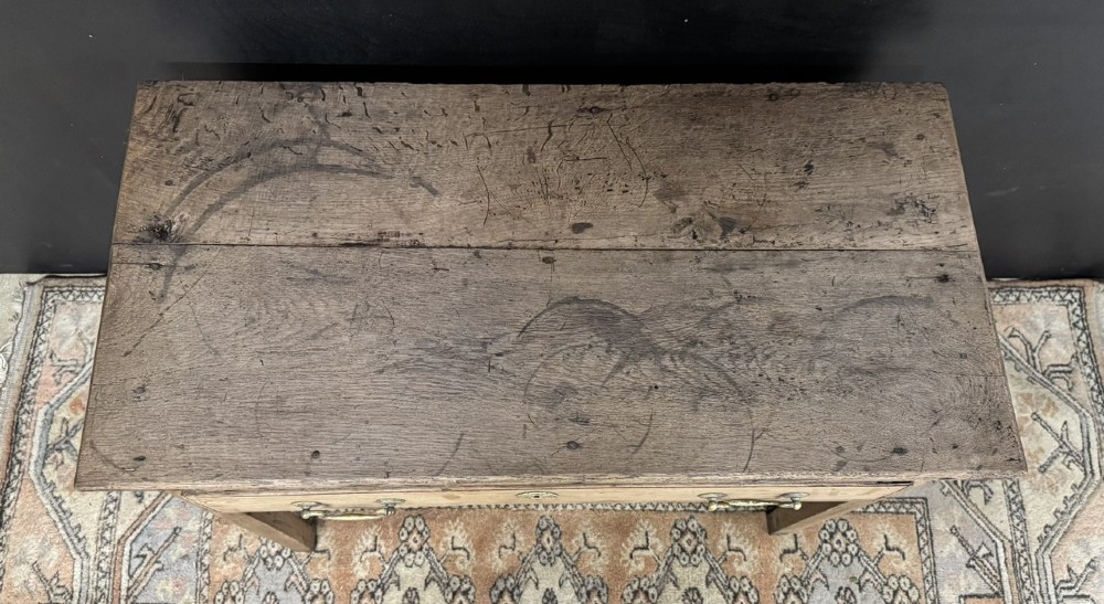 A Georgian natural oak side table with a wide single drawer, two brass swan-neck handles, a brass escutcheon, and four straight square legs. View IV