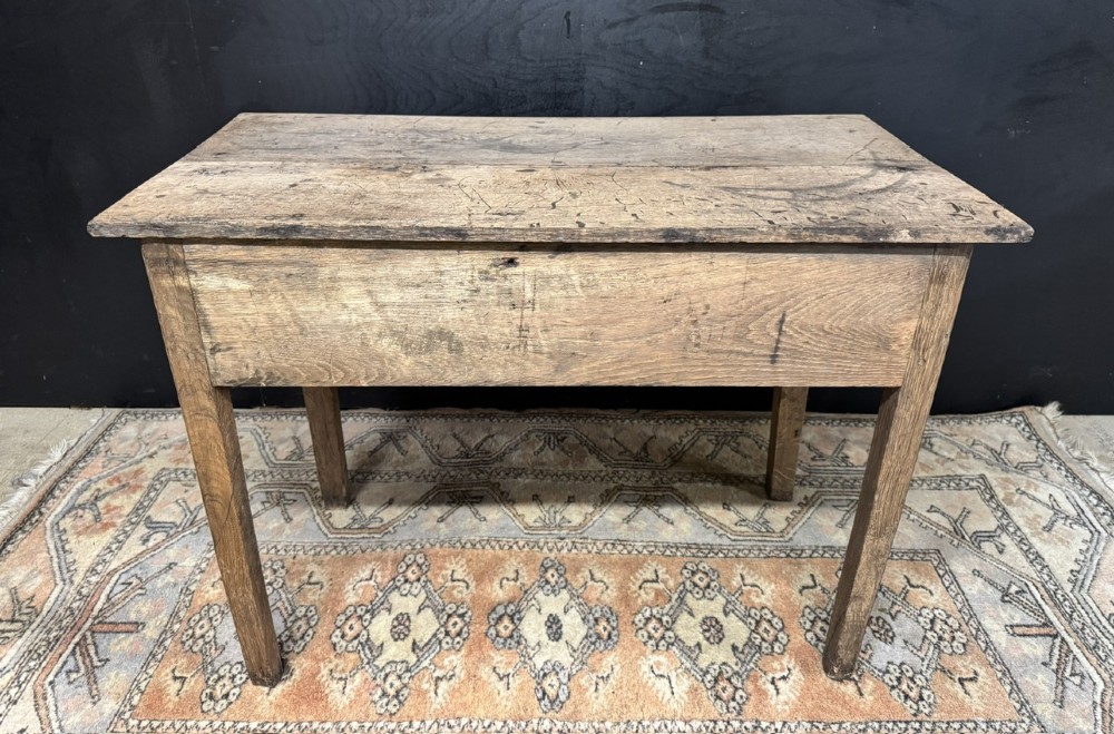 A Georgian natural oak side table with a wide single drawer, two brass swan-neck handles, a brass escutcheon, and four straight square legs. View IX