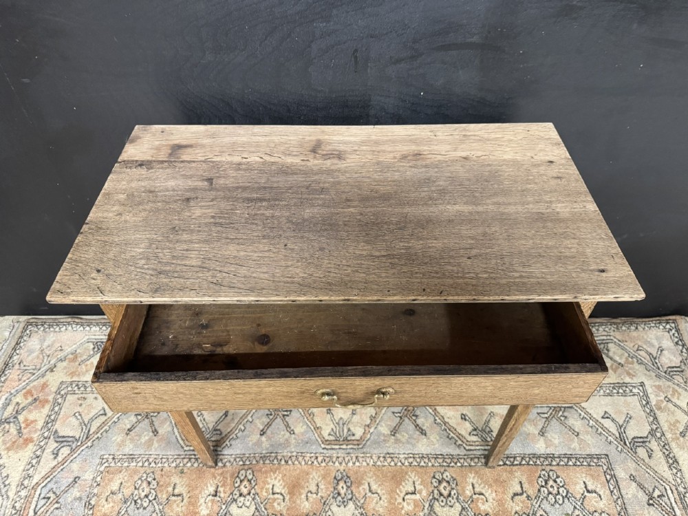 A Georgian oak side table featuring a single frieze drawer with a brass swan-neck handle and four square legs. View V