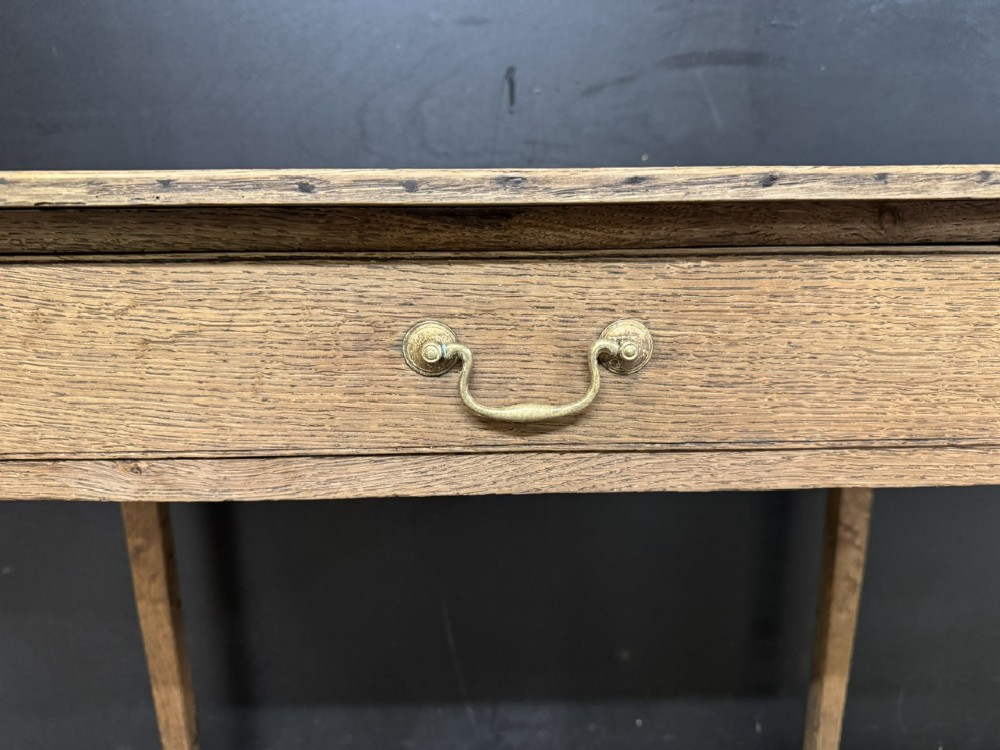 A Georgian oak side table featuring a single frieze drawer with a brass swan-neck handle and four square legs. View VI