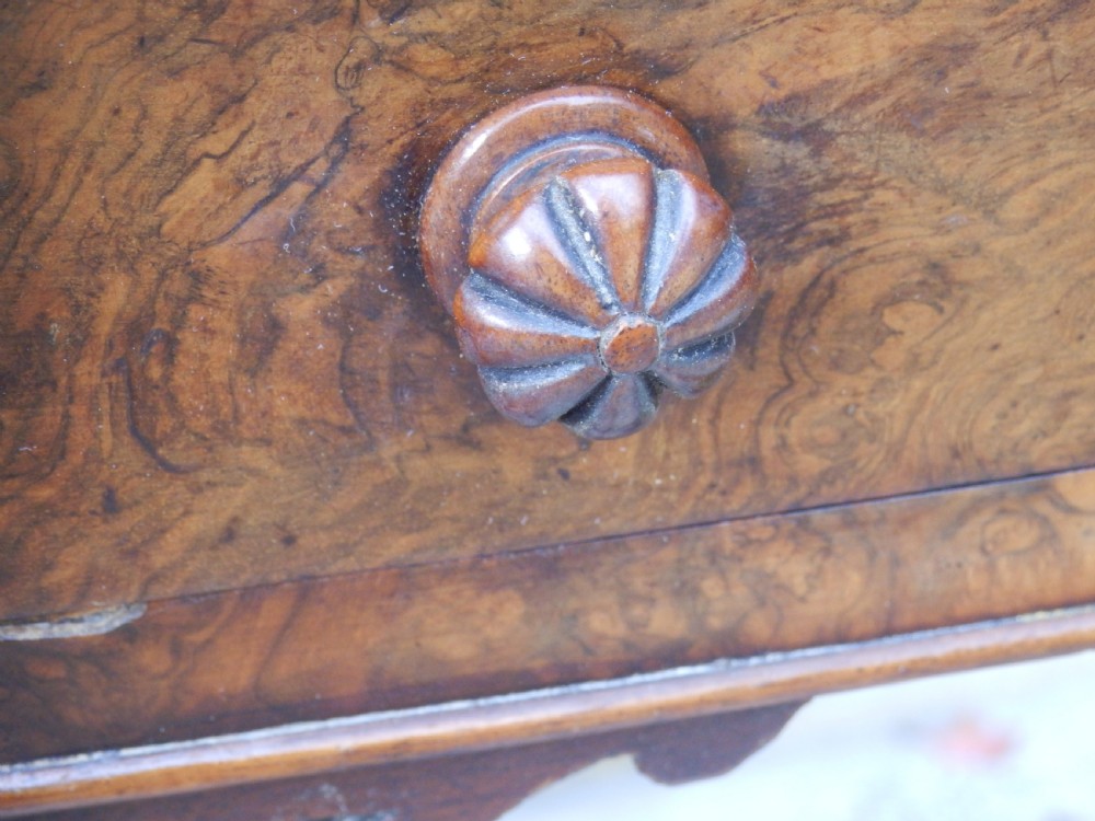 An early Victorian burr walnut writing desk featuring an inset leather writing top, carved frieze drawers, turned legs, and a raised central rear plinth. View VIII