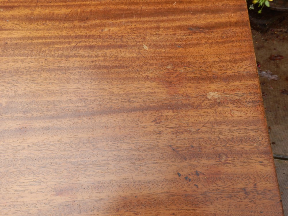 A rectangular mahogany tilt-top table displayed upright on a turned pedestal with splayed reeded legs and brass castors. View IX