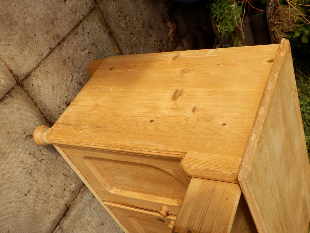 A Victorian pine dresser base with a top drawer, two arched recessed cupboard doors, turned wooden knobs, and brass escutcheons. View VIII