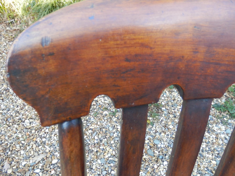 A Victorian wooden Windsor carver armchair featuring a high slat back, turned front legs, curved armrests, and a saddle seat in a dark brown timber finish. View II