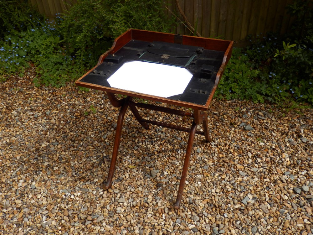 A Victorian mahogany folding writing desk featuring curved X-frame legs, an open writing tray top with a leather insert, and a built-in inkwell compartment. View VII