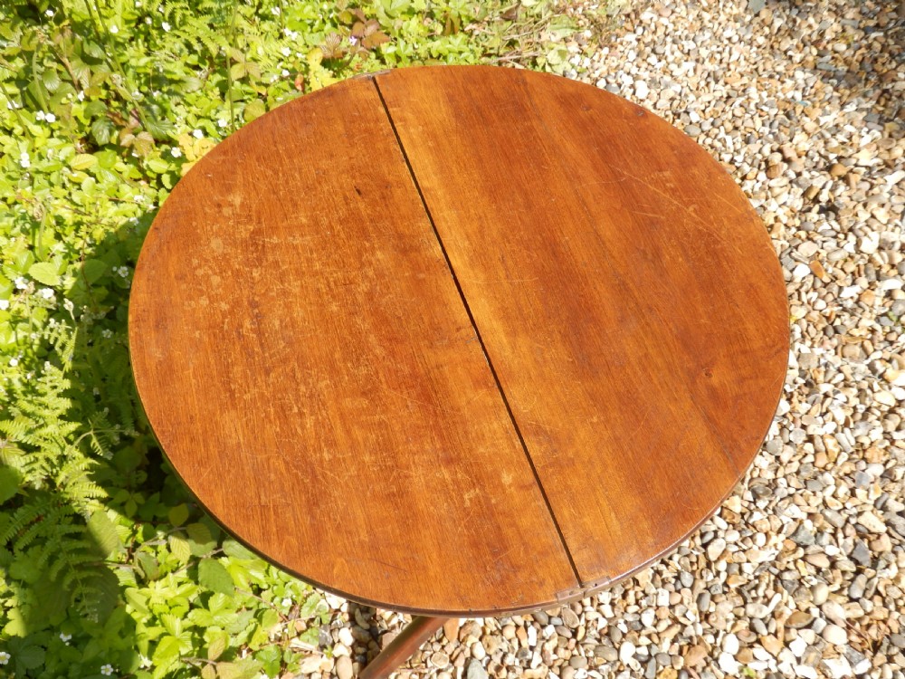 A Victorian mahogany folding coaching table featuring a circular top supported by an X-frame leg assembly with brass rim hinges. View IX