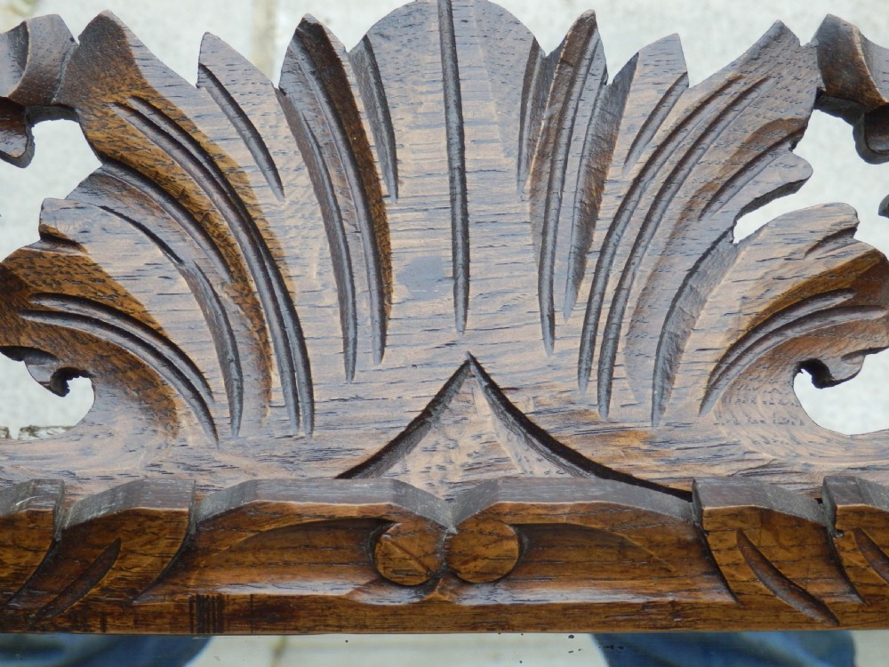 An Edwardian rectangular wall mirror set within a dark oak frame deeply carved with acanthus leaves and scrollwork motifs. View VI