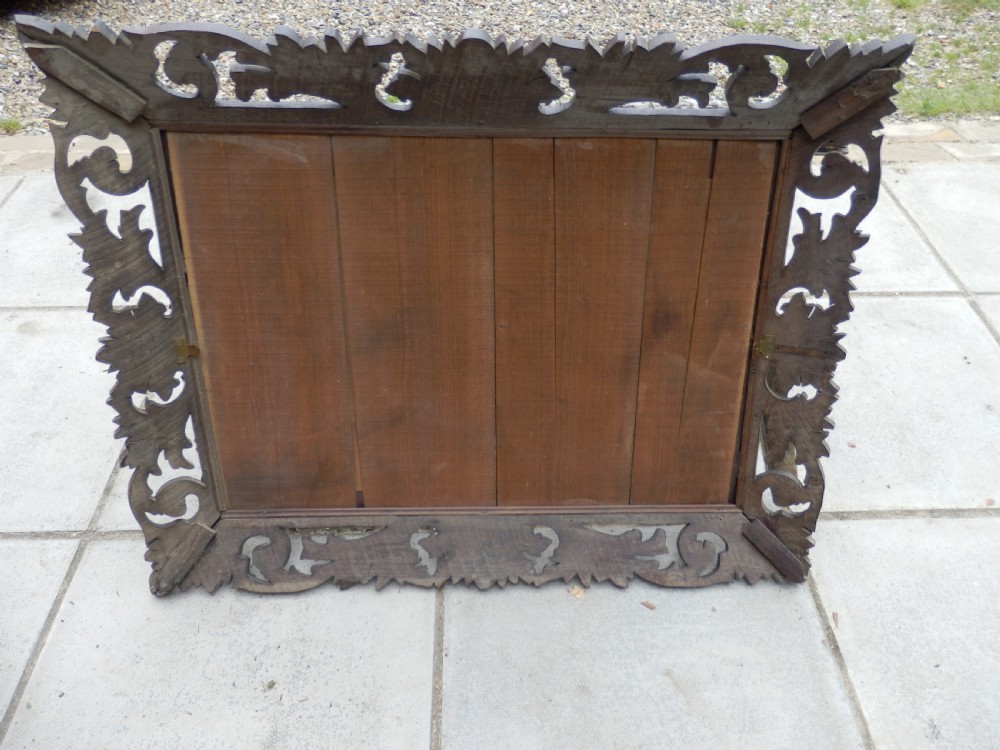 An Edwardian rectangular wall mirror set within a dark oak frame deeply carved with acanthus leaves and scrollwork motifs. View VII