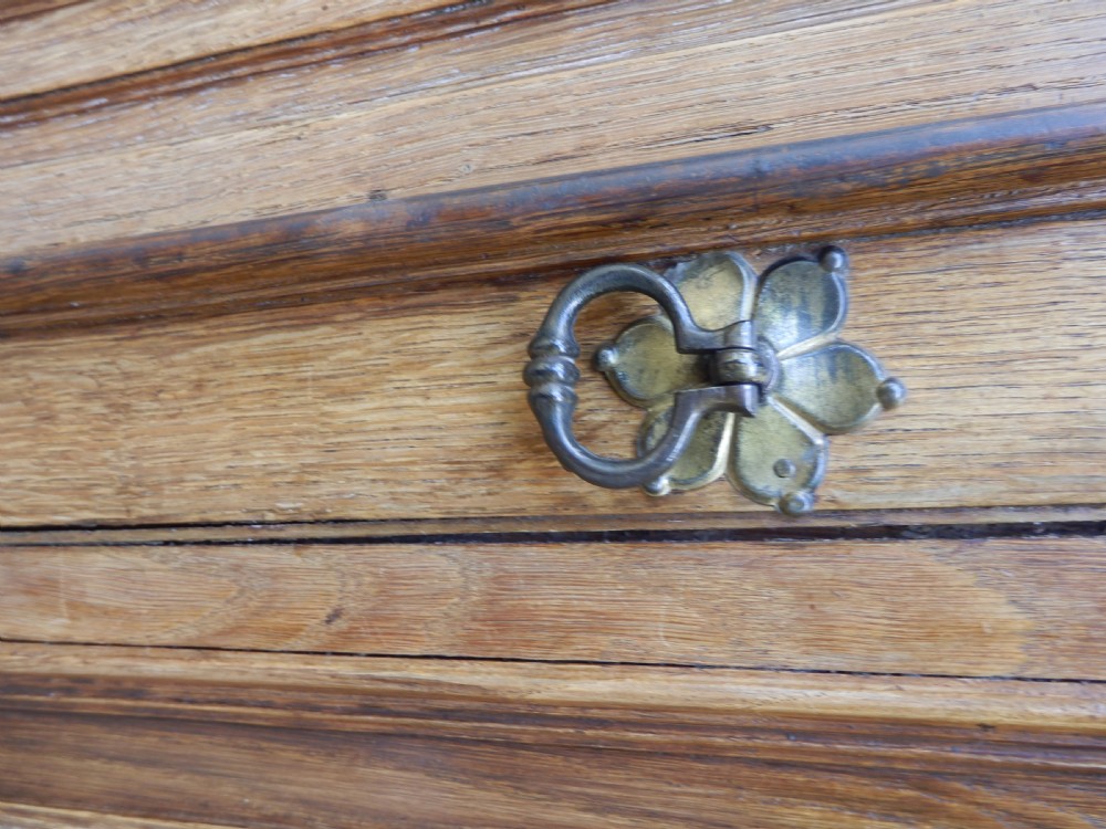 An 18th-century solid oak hall cupboard featuring double doors with geometric fielded panelling, lower drawers, and a stepped top cornice. View III
