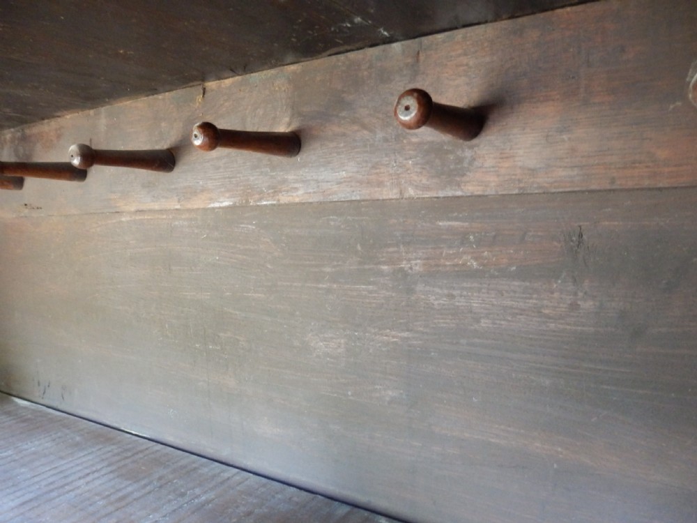 An 18th-century solid oak hall cupboard featuring double doors with geometric fielded panelling, lower drawers, and a stepped top cornice. View XII
