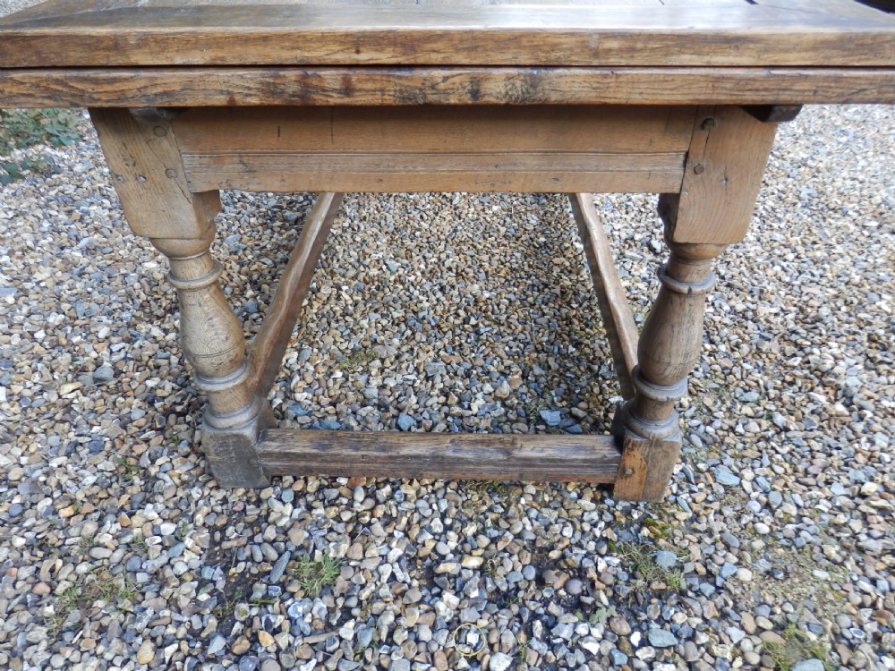 An extended antique Georgian oak dining table featuring turned legs, perimeter box stretchers, and draw-leaf extensions extending to 2.9 metres. View VI