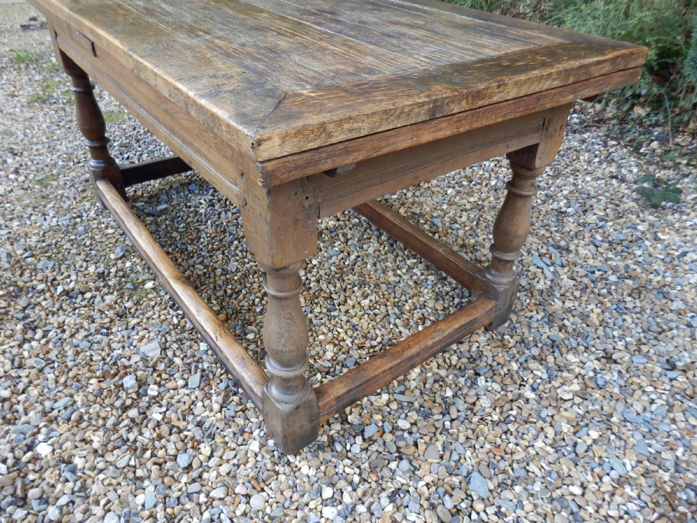 An extended antique Georgian oak dining table featuring turned legs, perimeter box stretchers, and draw-leaf extensions extending to 2.9 metres. View VIII