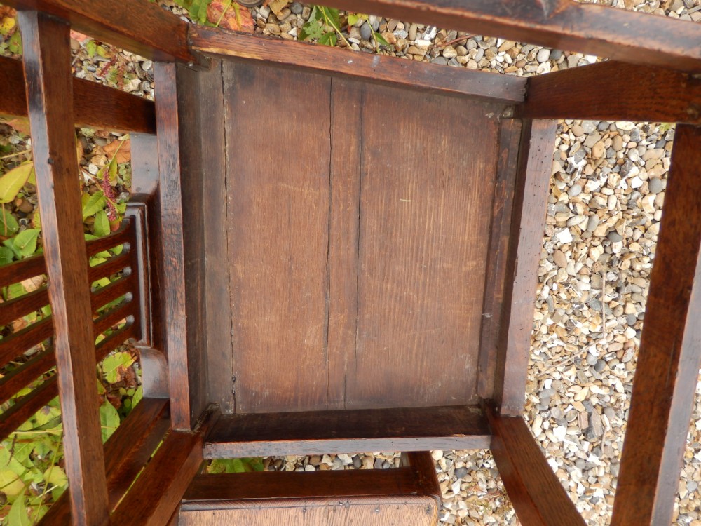 A set of six dark oak Georgian dining chairs featuring pierced vertical back splats, solid wooden seats, and straight legs connected by stretchers. View V