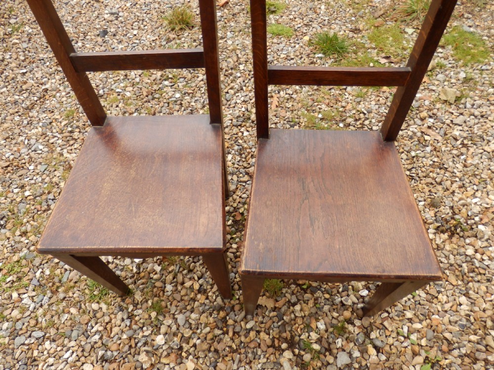 A pair of antique dark oak dining chairs with flat horizontal back slats, solid wood seats, and straight legs. View II