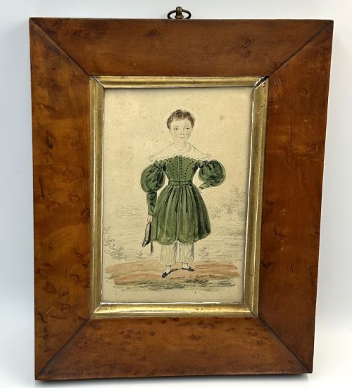 fig 1. An antique watercolour portrait of a child wearing a green dress framed in figured maple wood with a gilded inner rim.