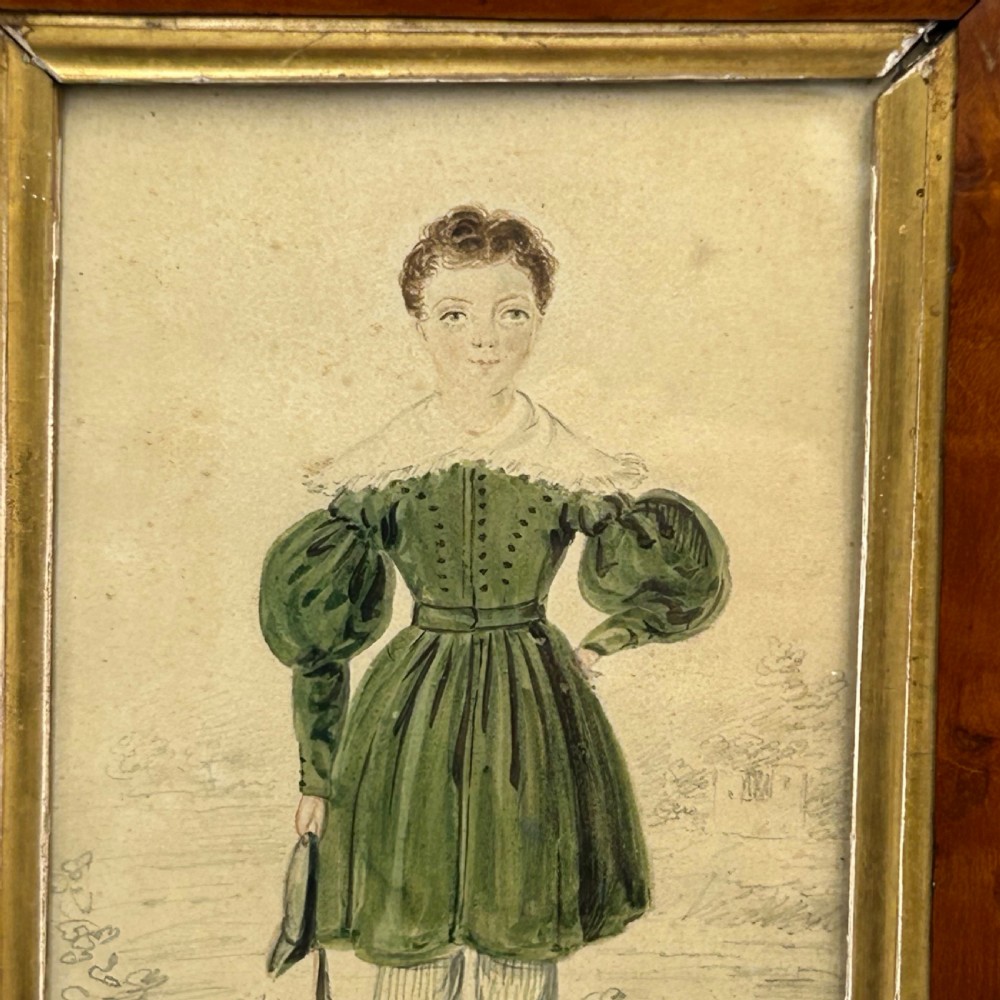 An antique watercolour portrait of a child wearing a green dress framed in figured maple wood with a gilded inner rim. View III