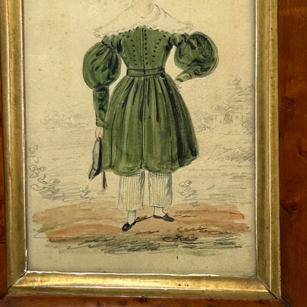 An antique watercolour portrait of a child wearing a green dress framed in figured maple wood with a gilded inner rim. View V
