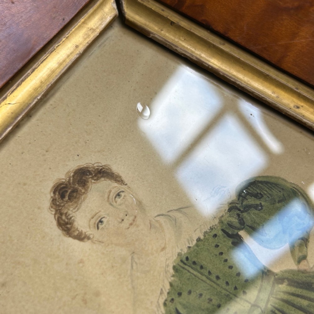 An antique watercolour portrait of a child wearing a green dress framed in figured maple wood with a gilded inner rim. View XI