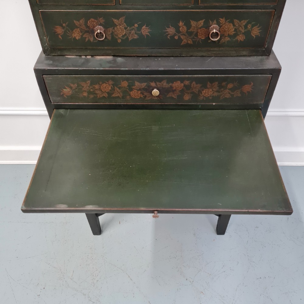 A dark green late Victorian collectors cabinet on a tall stand, featuring hand-painted floral motifs, multiple drawers, and brass ring handles. View IV