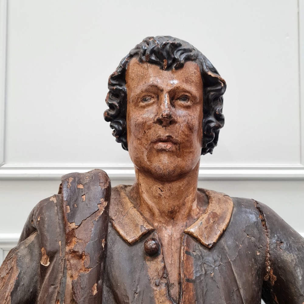 Full-length carved wood polychrome figure of a standing man in 17th-century attire on an inscribed rectangular base. View III