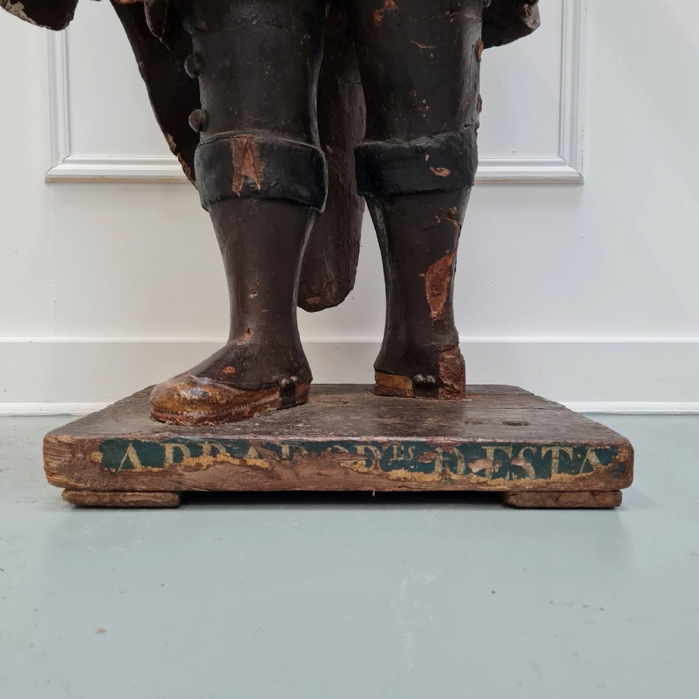 Full-length carved wood polychrome figure of a standing man in 17th-century attire on an inscribed rectangular base. View V