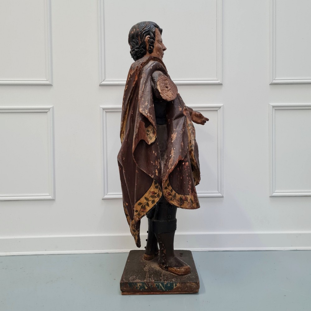 Full-length carved wood polychrome figure of a standing man in 17th-century attire on an inscribed rectangular base. View VI
