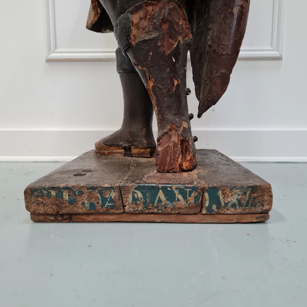 Full-length carved wood polychrome figure of a standing man in 17th-century attire on an inscribed rectangular base. View XI