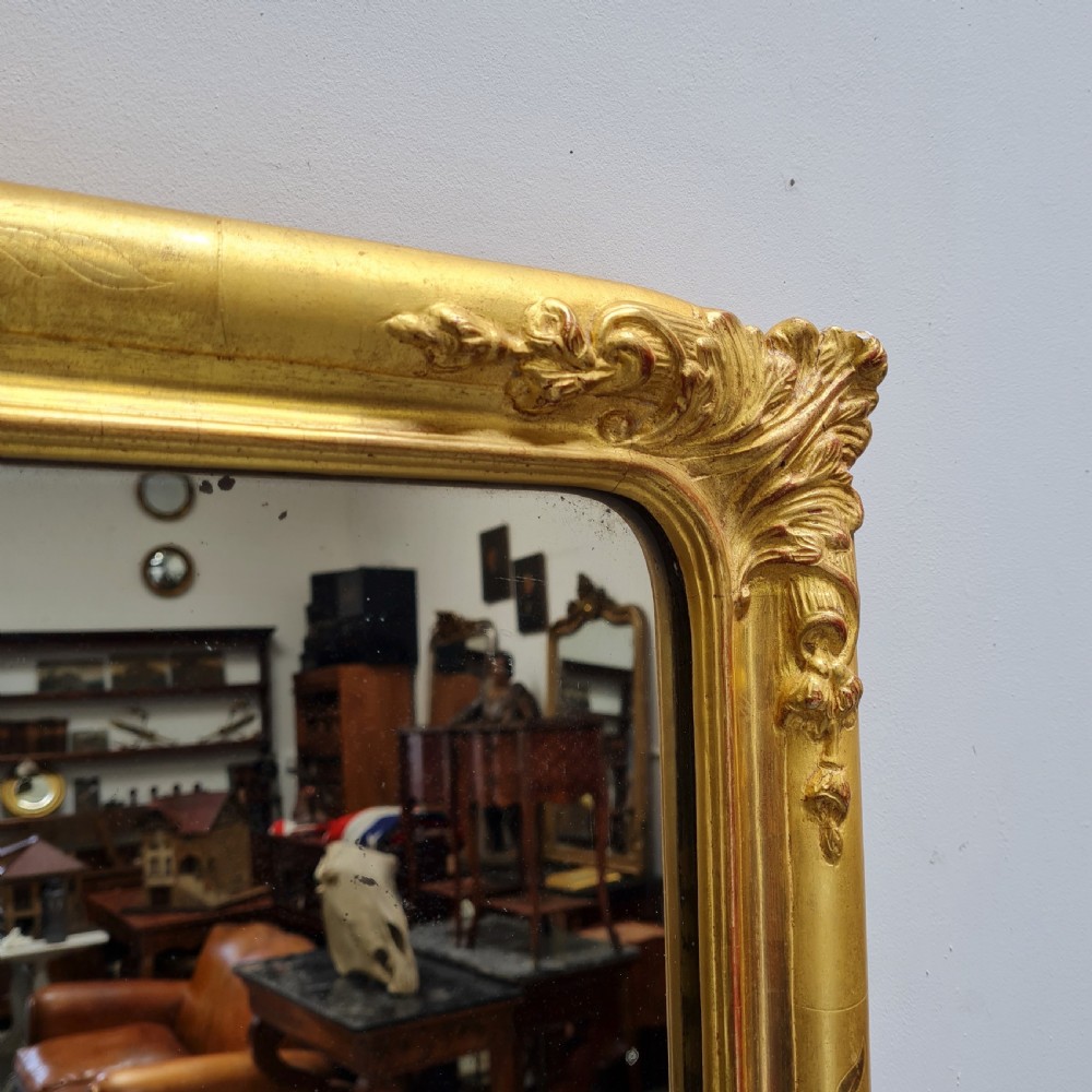 A tall rectangular French antique floor mirror featuring a gold gilded frame with rounded top corners and leaf details. View V