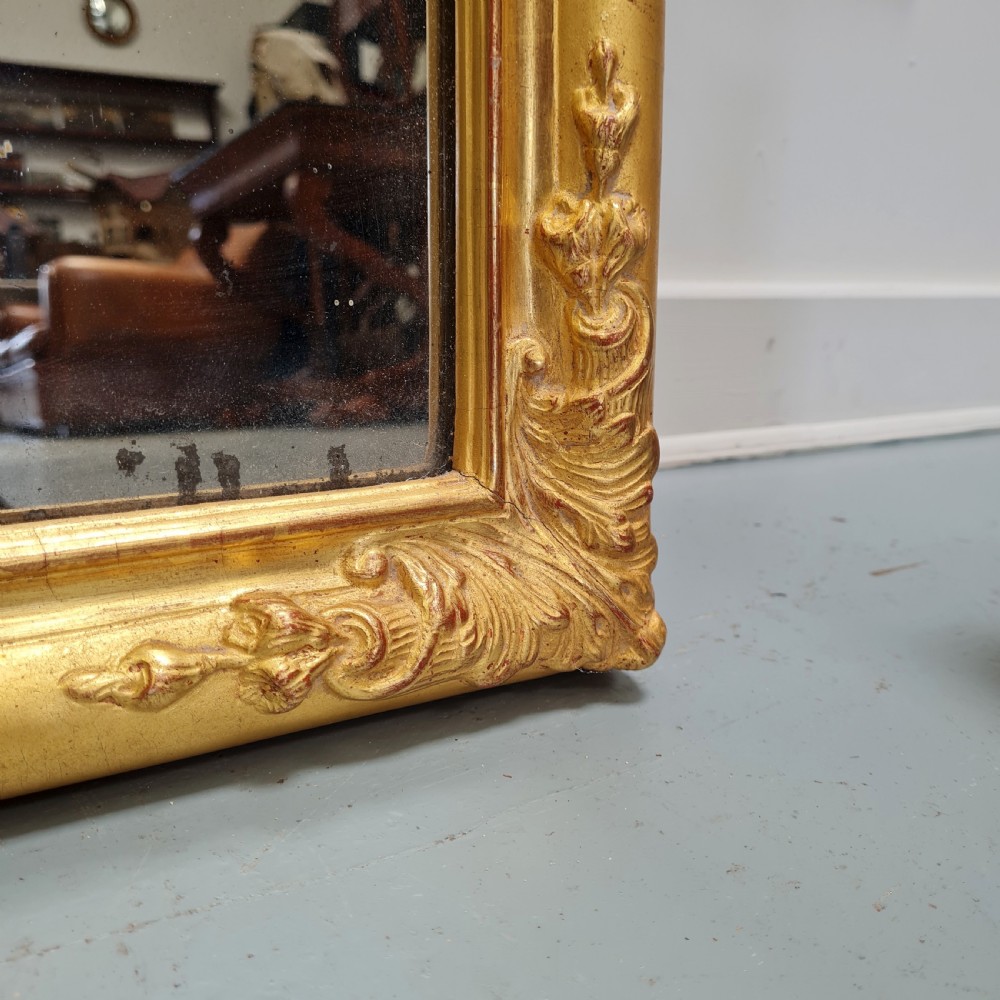 A tall rectangular French antique floor mirror featuring a gold gilded frame with rounded top corners and leaf details. View VI