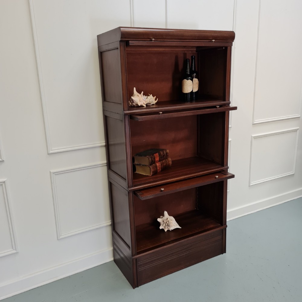 A tall dark mahogany 1930s French stacking haberdashery bookcase featuring two upper glazed compartments above a solid timber lower section. View III