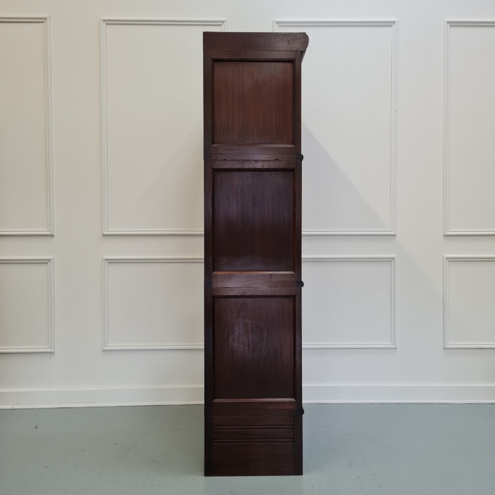 A tall dark mahogany 1930s French stacking haberdashery bookcase featuring two upper glazed compartments above a solid timber lower section. View VII