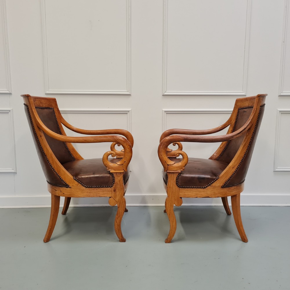 Pair of mid-19th-century ash wood armchairs featuring brown leather upholstery, stud detailing, and carved scrolled armrests. View II