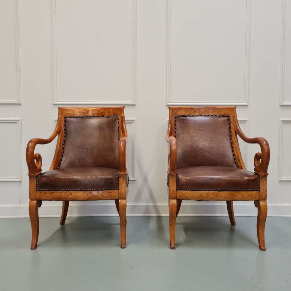 Pair of mid-19th-century ash wood armchairs featuring brown leather upholstery, stud detailing, and carved scrolled armrests. View IV