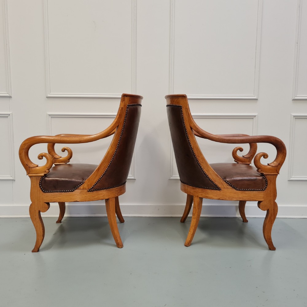 Pair of mid-19th-century ash wood armchairs featuring brown leather upholstery, stud detailing, and carved scrolled armrests. View VI