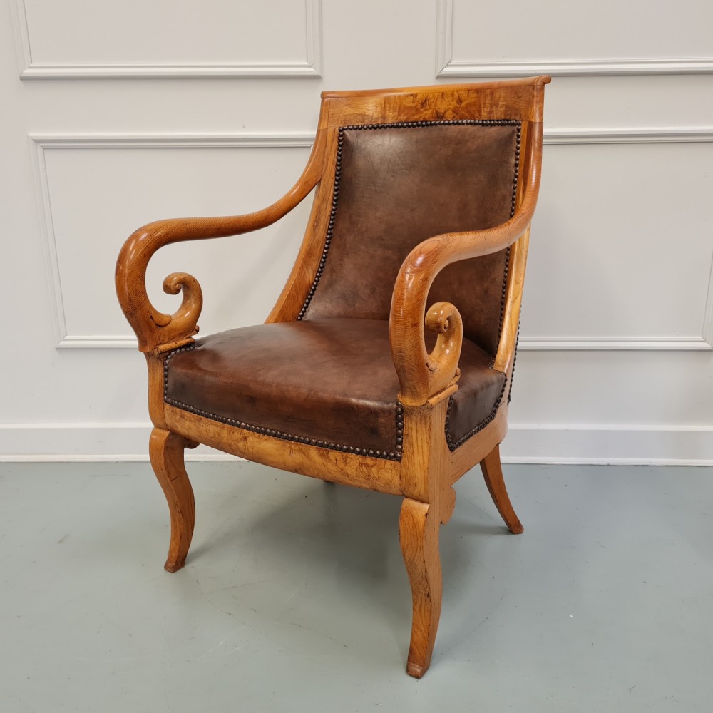 Pair of mid-19th-century ash wood armchairs featuring brown leather upholstery, stud detailing, and carved scrolled armrests. View IX