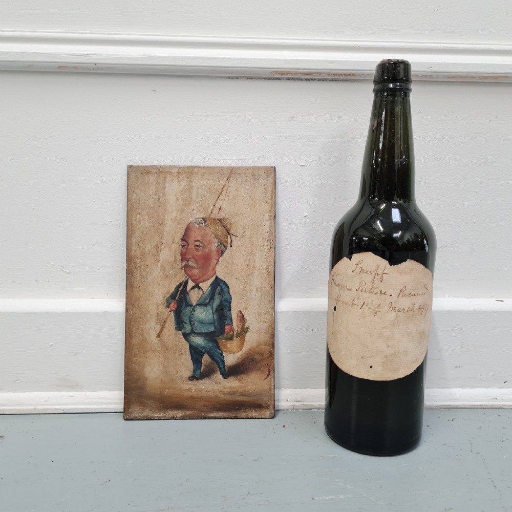 An antique oil painting on a rectangular wood panel depicting a caricatured fisherman with a moustache in a blue suit, holding a fishing rod and a basket containing fish. View V