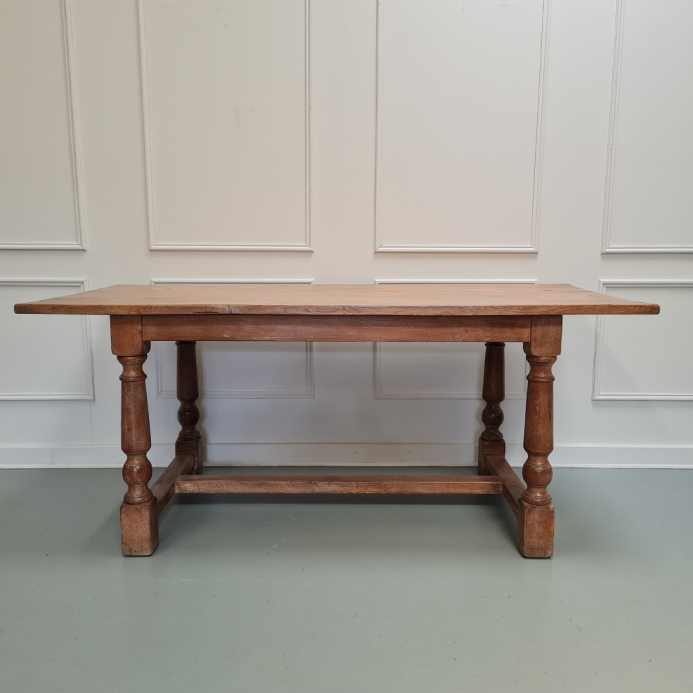 A late 19th-century oak refectory dining table featuring turned legs and a low rectangular stretcher base.