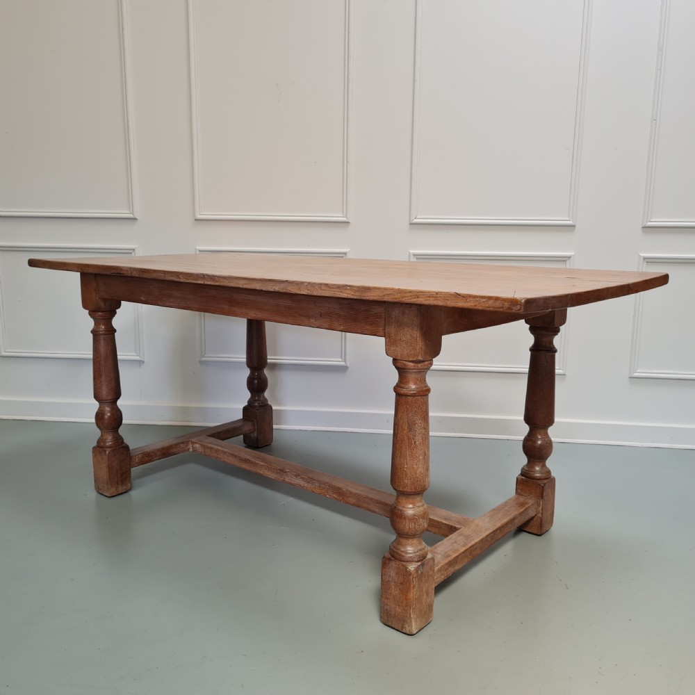 A late 19th-century oak refectory dining table featuring turned legs and a low rectangular stretcher base. View VII