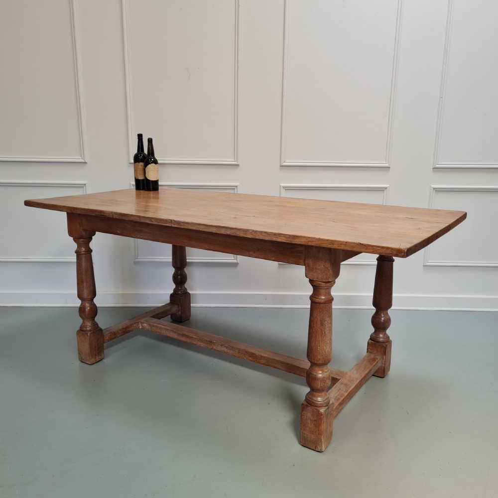 A late 19th-century oak refectory dining table featuring turned legs and a low rectangular stretcher base. View VIII