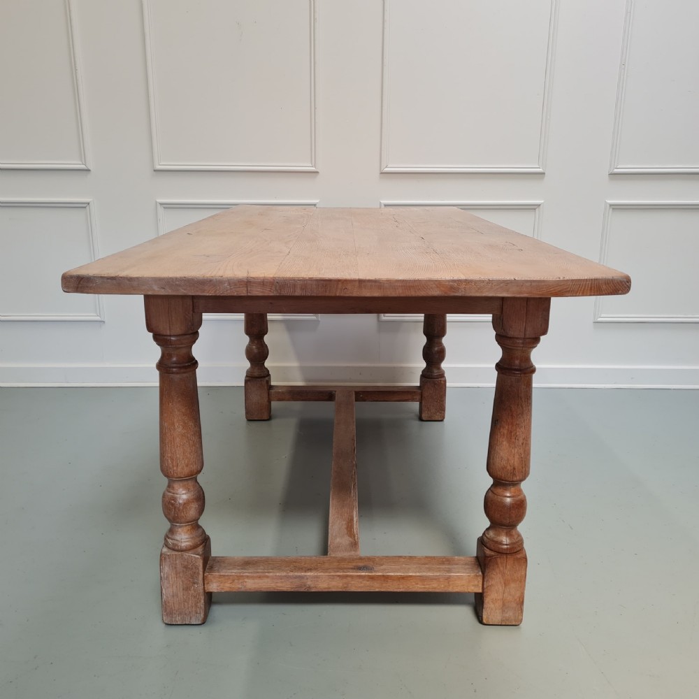 A late 19th-century oak refectory dining table featuring turned legs and a low rectangular stretcher base. View IX