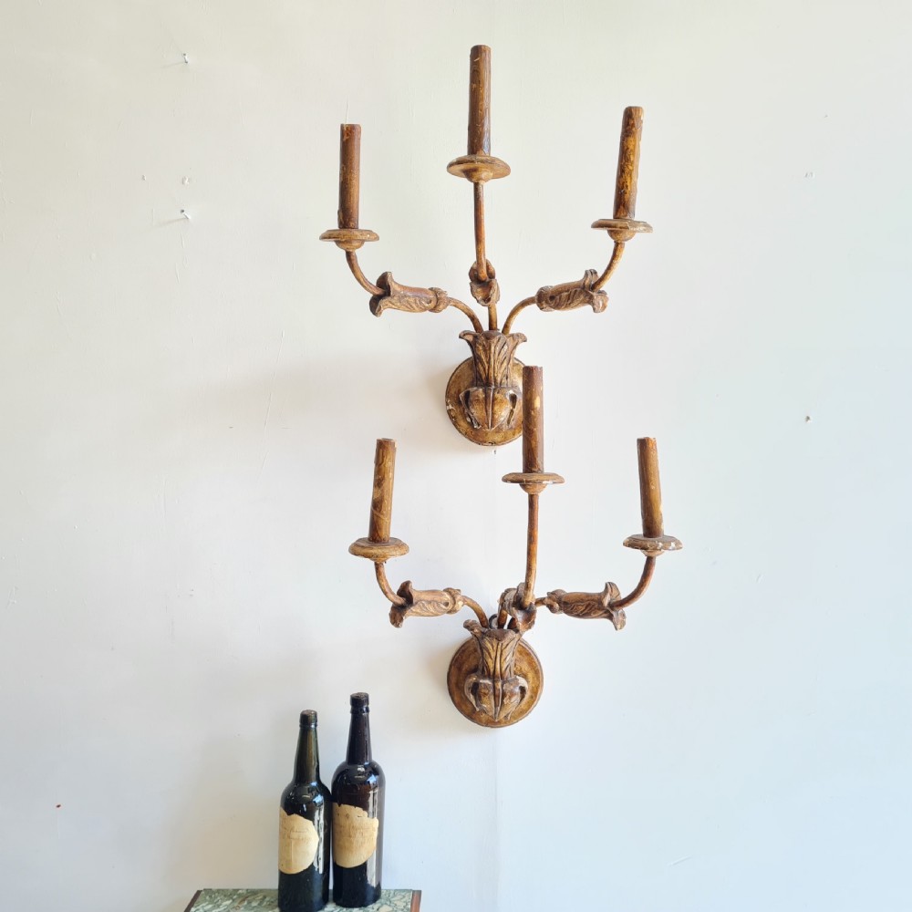 A pair of late 18th-century carved giltwood three-arm wall lights with foliate bases and slender curved arms. View III