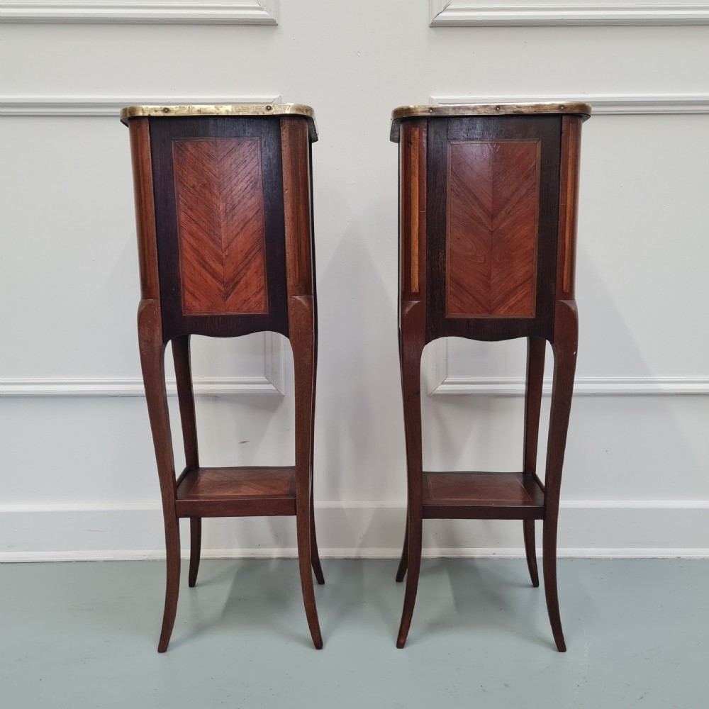 A pair of tall French kingwood bedside cabinets featuring three drawers, brass galleries, slender legs, and lower shelves. View IV