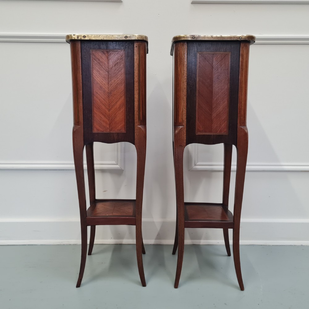 A pair of tall French kingwood bedside cabinets featuring three drawers, brass galleries, slender legs, and lower shelves. View VII