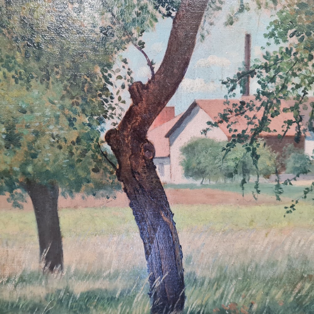 An antique French oil painting depicting trees in a grassy field with a tiled building in the background, set in a carved gilt inner frame and wide oak outer frame. View II
