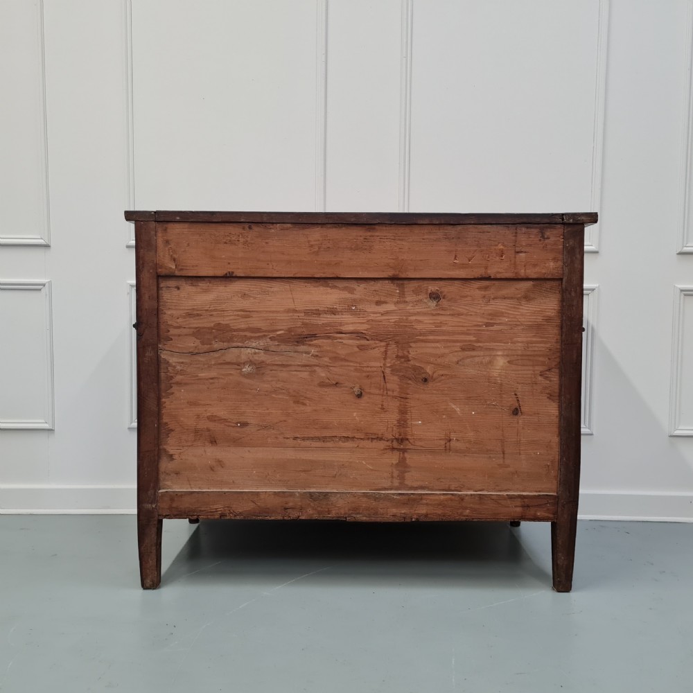 An early antique French cherry commode featuring three long drawers with brass drop handles and escutcheons. View VI