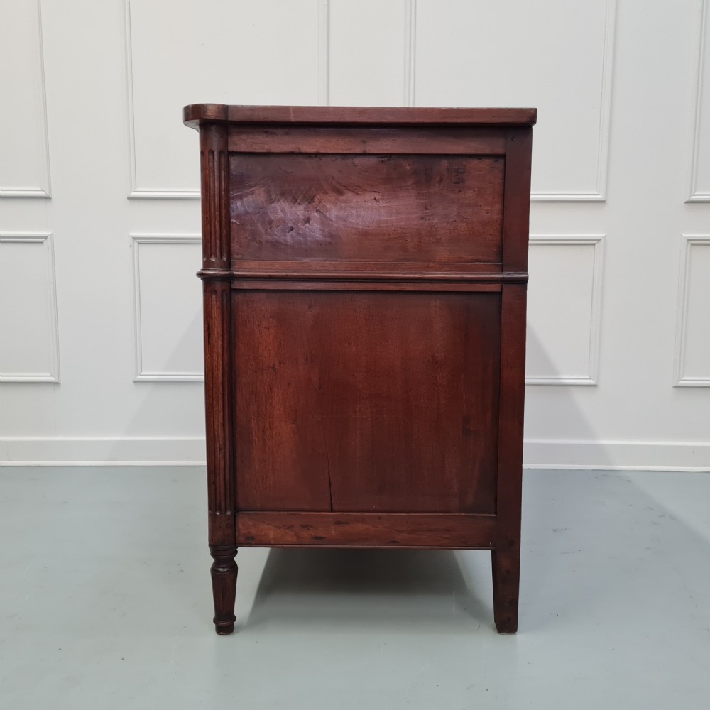 An early antique French cherry commode featuring three long drawers with brass drop handles and escutcheons. View VII