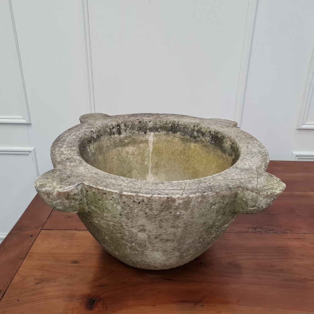 An 18th-century carved white marble mortar featuring four lug handles and a worn interior basin. View II